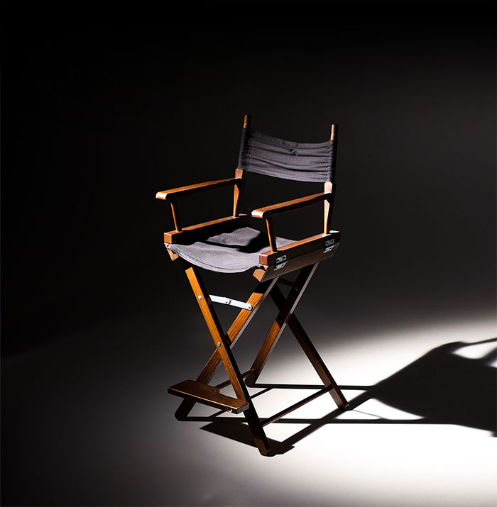 Directors,Chair,Stands,In,The,Beam,Of,Light.,Space,For Directors chair stands in the beam of light. Space for text.